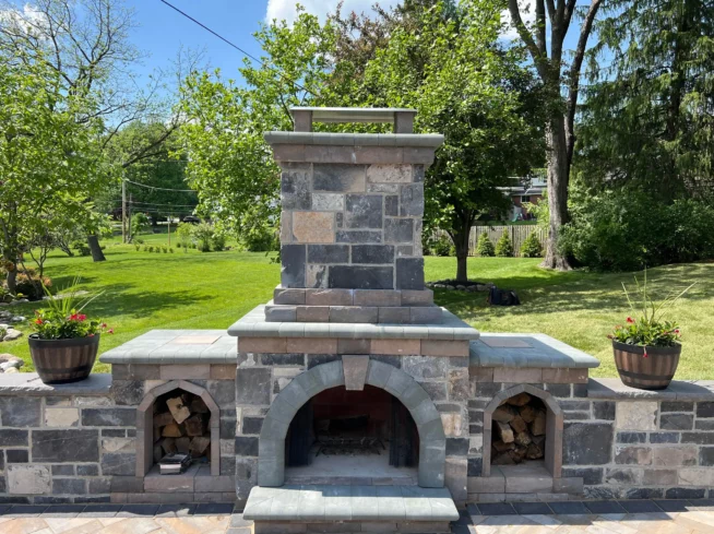 Custom outdoor fireplace built by ScapeWorx using premium stone masonry