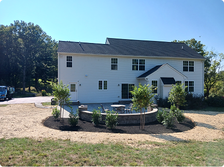 ScapeWorx backyard patio installation with fire pit and fresh mulch around new plantings
