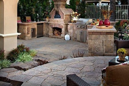 Elegant outdoor kitchen with pizza oven and grill by ScapeWorx.