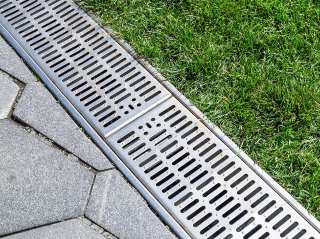 ScapeWorx-installed channel drain system between pavers and lawn
