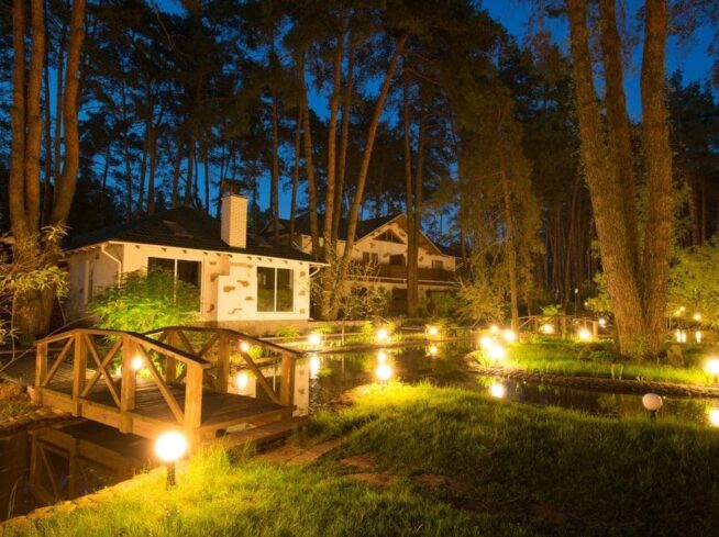 Outdoor lighting design for wooded backyard with bridge and pond