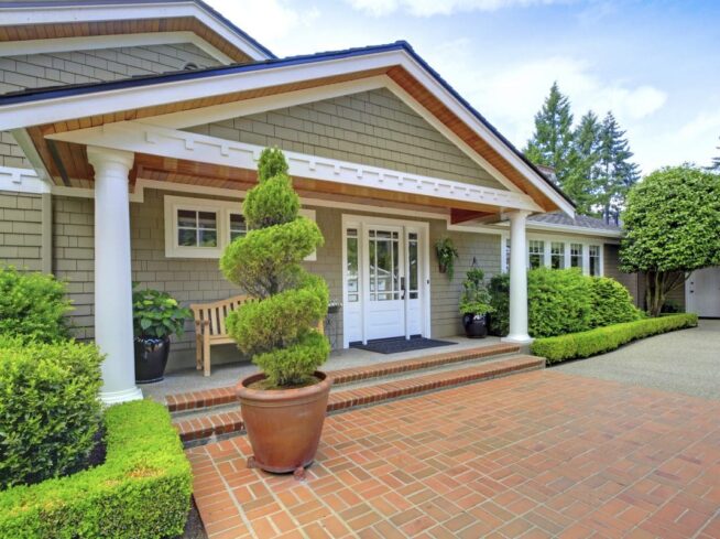 Clean hardscape entryway with topiary accents and manicured greenery by ScapeWorx