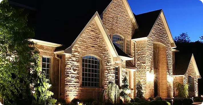 Elegant outdoor landscape lighting on a stone home in Glen Mills, PA,