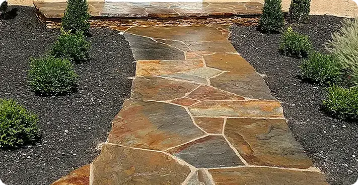 Freshly sealed natural flagstone walkway with enhanced color and wet-look finish, demonstrating professional paver sealing services