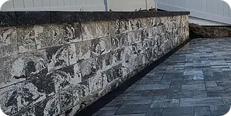 Stained retaining wall and adjacent paver patio s