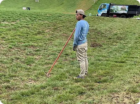 ScapeWorx Crew member standing in lawn during aeration prep work