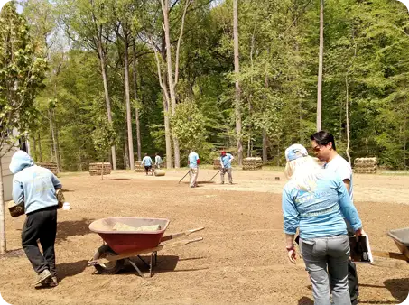Careers in landscaping at Work! ScapeWorx crew preparing ground for sod installation with wheelbarrows and rakes