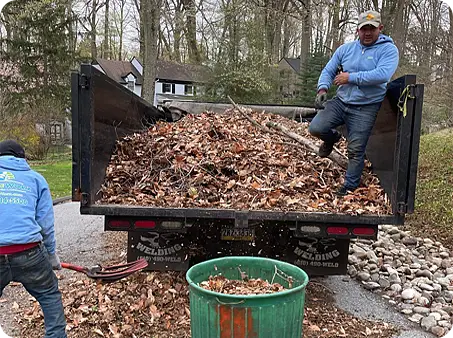 The ScapeWorx leaf cleanup crew unloading trailer packed with debris