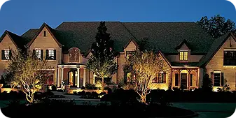 Elegant estate landscape lighting with tree uplights and entry columns lit