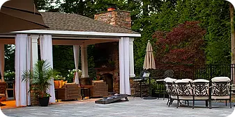 Covered outdoor living pavilion with lounge seating and fireplace in Thornbury all installed by ScapeWorx