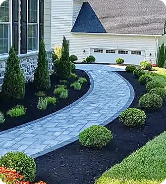 Curved walkway with pavers and neatly trimmed shrubbery.
