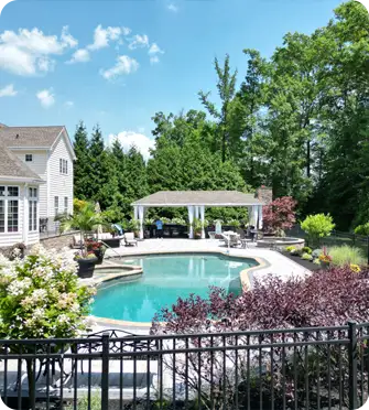 A classic ScapeWorx backyard poolscape with custom hardscaping, landscaping, and shaded pavilion in Wilmington