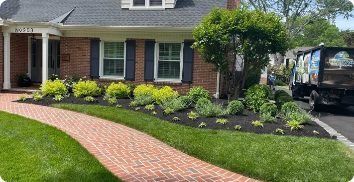 Front yard in Wilmington with refreshed landscape bed and curved brick walkway all by ScapeWorx