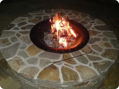 Stone fire pit with a crackling fire at night