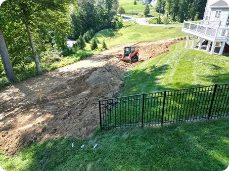 ScapeWorx performing precise grading on a sloped backyard using specialized equipment to prepare for lawn installation and erosion control.