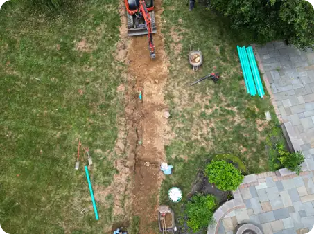 ScapeWorx trenching and drainage pipe installation in progress to improve lawn drainage and protect the landscape from water issues.