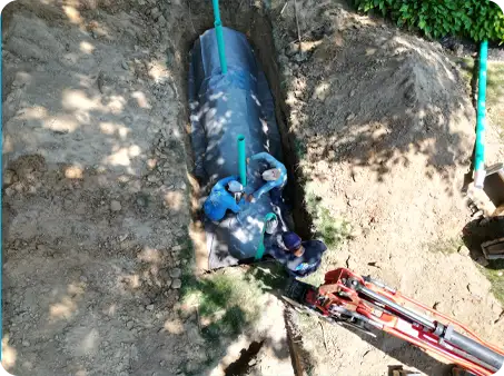 ScapeWorx crew installing advanced drainage system with fabric wrap and piping to manage groundwater and prevent landscape flooding.