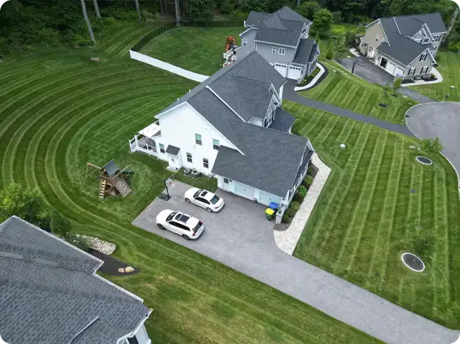 Aerial view of a perfectly mowed lawn with neat, parallel stripes, maintained by ScapeWorx.
