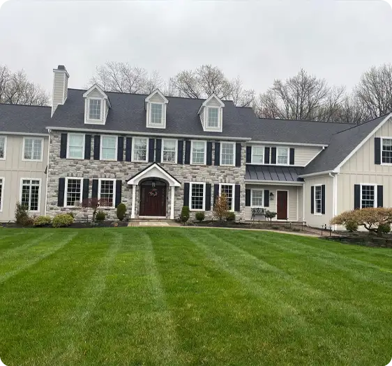 Neatly mowed lawn with crisp, defined lines in front of a beautiful home, maintained by ScapeWorx.