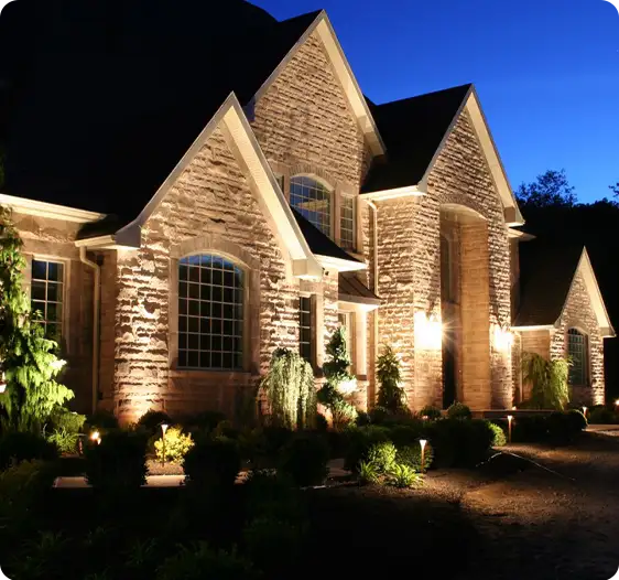 ScapeWorx landscape lighting showcasing elegant uplighting on a stone home, emphasizing architectural lines and adding security at night.