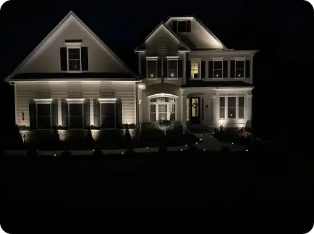 ScapeWorx landscape lighting highlighting the front facade of a home at night.