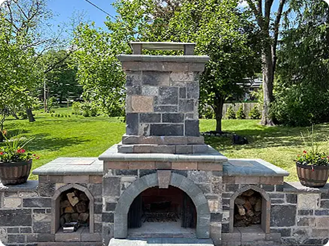 Custom masonry outdoor fireplace with storage for firewood.