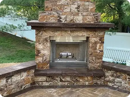 Stone outdoor fireplace with built-in seating.
