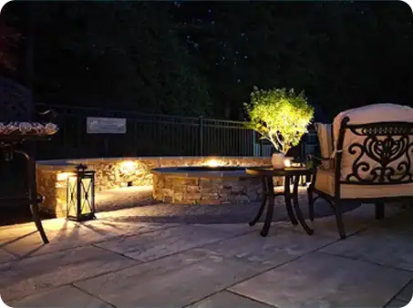Nighttime patio with stone seating wall and tranquil lighting