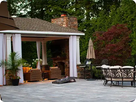 Outdoor patio with seating area and fireplace under gazebo