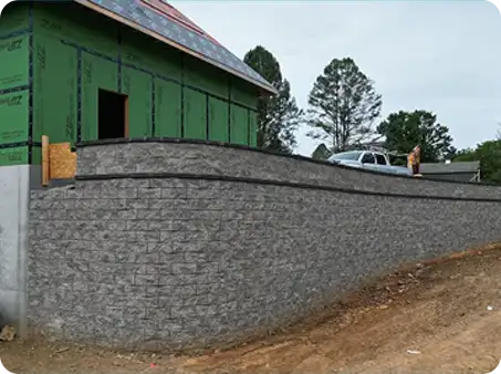 Large retaining wall with smooth stonework at construction site