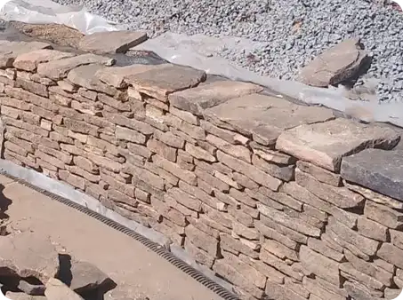 Close-up of a stone retaining wall being built