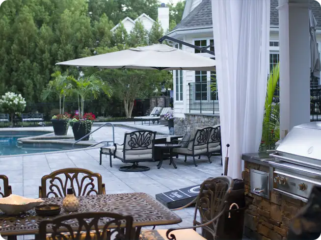 Shaded poolside lounge with patio seating by ScapeWorx