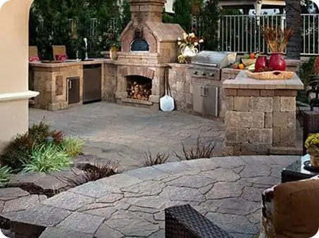 Elegant outdoor kitchen with pizza oven and grill by ScapeWorx.