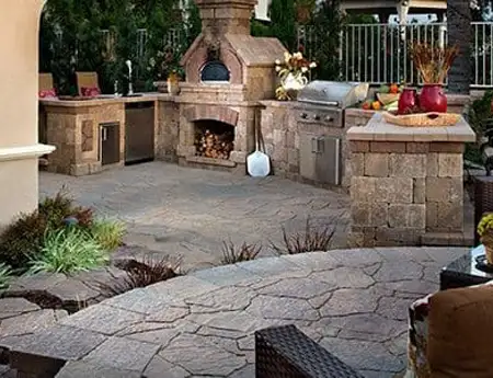 Elegant outdoor kitchen with pizza oven and grill by ScapeWorx.