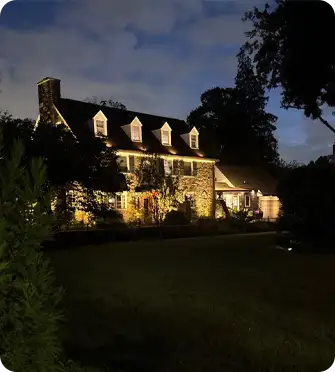 Elegant stone home with architectural landscape lighting by ScapeWorx