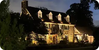 Elegant stone home with architectural landscape lighting by ScapeWorx