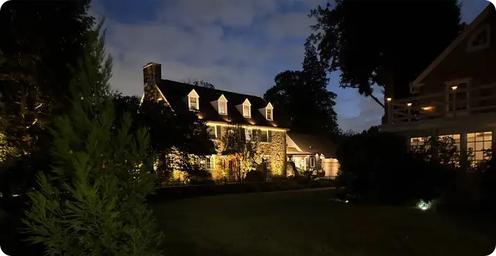 Elegant stone home with architectural landscape lighting by ScapeWorx