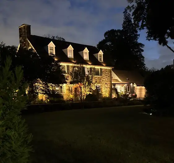 Elegant stone home with architectural landscape lighting by ScapeWorx