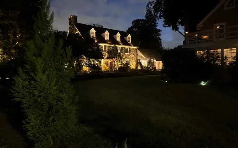 Elegant stone home with architectural landscape lighting by ScapeWorx