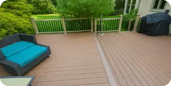 Spacious composite patio deck in Kennett Square designed by ScapeWorx, featuring warm brown planks, black railings, and outdoor seating with teal cushions.