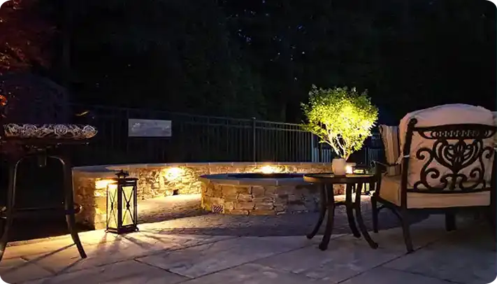 ScapeWorx landscape lighting in Delaware County illuminating a backyard patio and seating area.
