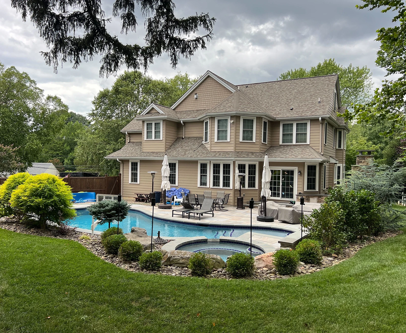 ScapeWorx outdoor living area with pool, spa, and landscaped stonework