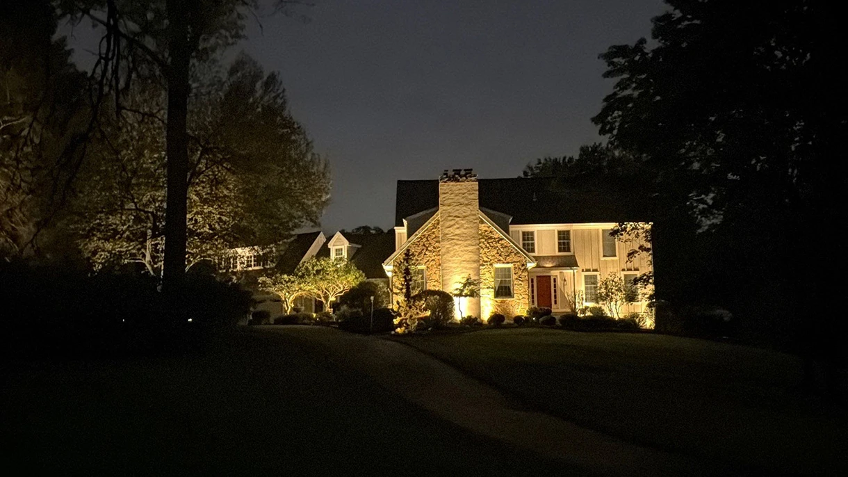 Illuminated stone home and ornamental trees, showcasing ScapeWorx outdoor lighting for homeowners in Media, PA.